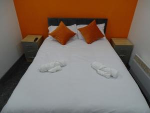 a bedroom with a bed with two slippers on it at The Orange Outpost 8a - City Centre in Bradford