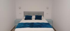 a bedroom with a bed with blue pillows at El Rincón de Perez A in Ajo