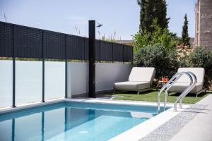 a swimming pool with a fence and a chair next to it at VillaSaints I Private Pool Villas, Walk to Beach, BBQ in Chania Town +49 photos
