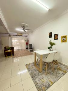 un salon avec une table et des chaises dans l'établissement TheMerits Homestay, à Ipoh