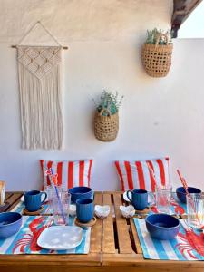 a wooden table with blue bowls and plates on it at La Necora Lanzarote in Playa Honda