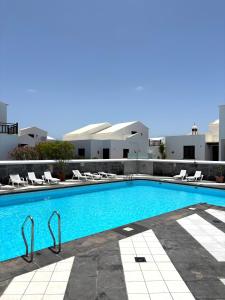 a large swimming pool with chairs and a building at La Necora Lanzarote in Playa Honda