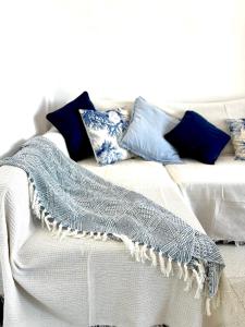 a couch with pillows and a blanket on it at La Necora Lanzarote in Playa Honda +15 photos