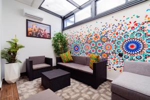 a living room with a colorful mural on the wall at Résidence Cerezo - Palmier in Maarif
