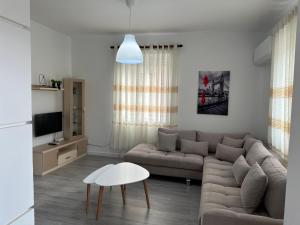 een woonkamer met een bank en een tafel bij Apartment Center Korça in Korçë