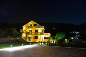 a large yellow house at night with its lights on at Villa Jovanovic in Tivat