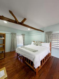 a bedroom with a bed with white sheets and wooden floors at Victory Homes in Dar es Salaam +119 photos