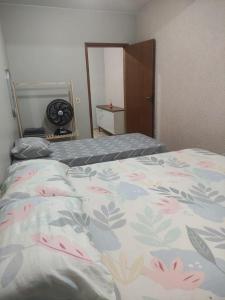 a bedroom with a bed with a flowered blanket at Apartamento bem localizado para até 4 hóspedes in Brasilia