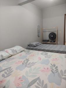 a bedroom with a bed with a floral bedspread at Apartamento bem localizado para até 4 hóspedes in Brasilia