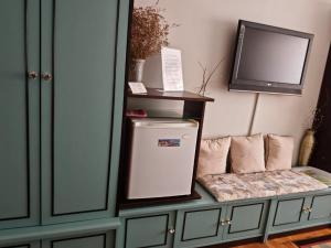 a tv sitting on top of a cabinet with a refrigerator at Guest House Plavas in Sozopol
