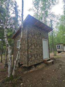 a small stone building with a door in the woods at Happy Trails Hideout #2 in Houston +19 photos