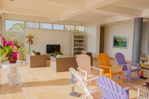 Arroyo de PiedraCabaña Cerca de Cartagena的客厅配有五颜六色的椅子和桌子