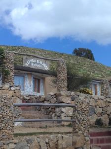 a stone building with a sign on top of it at Refugio Ecologico Kalluchi in Comunidad Yumani