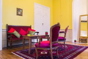 sala de estar con mesa, sillas y sofá en Appartement Le Buffon en Dijon