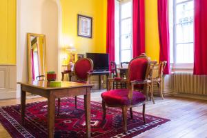 Habitación con sillas rojas, mesa y espejo. en Appartement Le Buffon, en Dijon