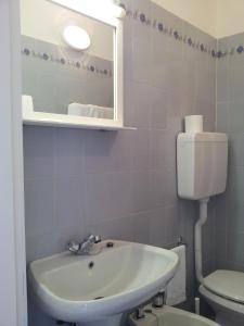 La salle de bains est pourvue d'un lavabo et de toilettes. dans l'établissement Hotel Elandra, à Bordighera