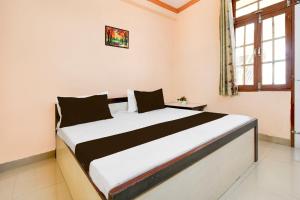 a bedroom with a large bed in a room at Hotel O New Shagun Vatika Lawn & Hotel in Alambagh