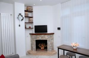 a living room with a fireplace with a flat screen tv at Perla D'Itria in Locorotondo +5 photos
