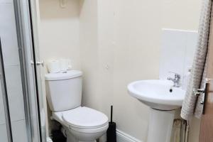 a white bathroom with a toilet and a sink at 1 Bed - Sleeps 4 - Wolverhampton City Centre in Wolverhampton