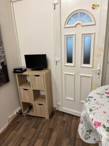 Un dormitorio con una puerta y un escritorio con una computadora. en Bien venu au studio B, en Clichy