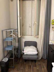 Una habitación con una silla, un armario y un estante. en Bien venu au studio B, en Clichy