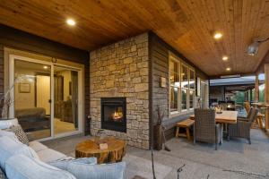 an outdoor living room with a stone fireplace at Prospector Pines Treetop Escape in Suncadia- Fairway View, BBQ, Outdoor Fireplace, Smart TVs, Hi-speed Wi-Fi in Cle Elum
