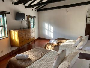 sypialnia z 2 łóżkami, komodą i oknami w obiekcie Aparta Hotel Eucalyptus w mieście Villa de Leyva