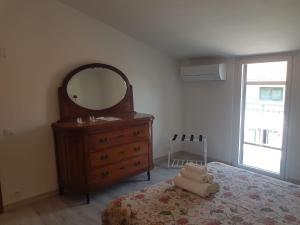 a bedroom with a dresser and a mirror and a bed at CasaLisetta in Serracapriola
