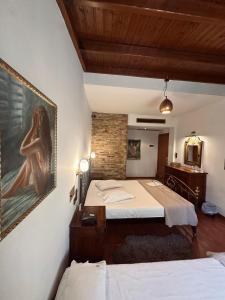 a bedroom with two beds and a painting on the wall at Alfa Hotel in Piraeus