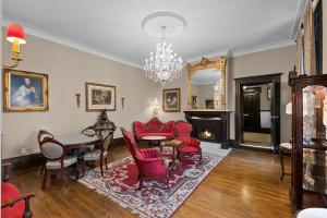 a living room with red chairs and a table and a fireplace at Le Clos Saint-Louis - Par Aneyro in Quebec City