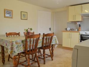 a kitchen with a table with four chairs and a kitchen with a stove at East Monkton Farm Cottage in Wick