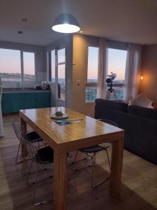 a living room with a wooden table and chairs at Complejo Phira in Puerto Pirámides
