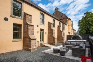 an exterior view of a house with a patio at Northumberland Hot Tub Haven for 10 in 5 ensuite bedrooms in Chatton