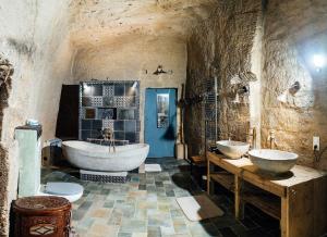a large bathroom with two sinks and a tub at La Galerie des voûtes oubliées in Doué-la-Fontaine