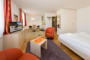 グレヘンにあるPostgebäudeのベッド、ソファ、テレビが備わるホテルルームです。