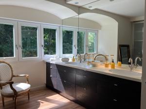 a bathroom with two sinks and two mirrors at Villa Julian Doppelzimmer Süd in Aurich