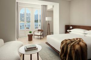 a bedroom with a bed and a chair and a window at The Lake Como EDITION in Griante Cadenabbia