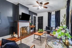 a living room with a fireplace and a ceiling fan at Private 1BR Suite Walk to Downtown Lafayette in Lafayette