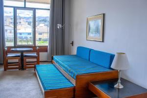 Real Hotel Huascaran في هواراس: غرفة معيشة مع أريكة زرقاء وطاولة