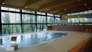 una gran piscina en un edificio con ventanas en El Salugral Termal Resort, en Hervás