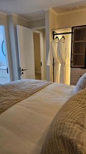 a bedroom with a bed and two white dresses on hangers at LUUM by Norus in Santiago