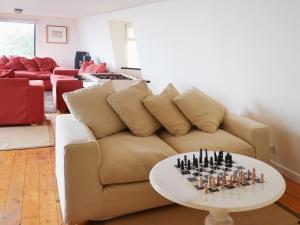 ein Wohnzimmer mit einer Couch und einem Schachbrett auf einem Tisch in der Unterkunft Seacliff Cottage in Strete