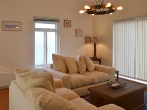 ein Wohnzimmer mit Sofa und Tisch in der Unterkunft Seacliff Cottage in Strete + 32 Fotos