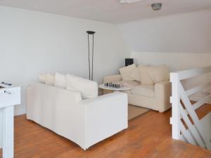 ein Wohnzimmer mit einer weißen Couch und einem Tisch in der Unterkunft Seacliff Cottage in Strete