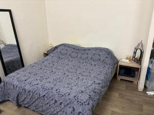 a bedroom with a bed with a blue comforter at Bien venu studio A in Clichy