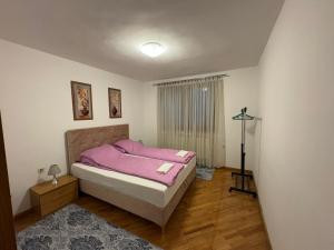 ein Schlafzimmer mit einem Bett mit einer rosa Decke in der Unterkunft Casa Bella Stup in Sarajevo