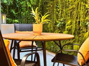 a wooden table with a potted plant on a patio at Exclusive Retreat off the Sea Front Promenade in Il-Gżira