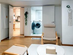 een woonkamer met een wasmachine en een stoel bij Bandal Stay in Daegu in Daegu