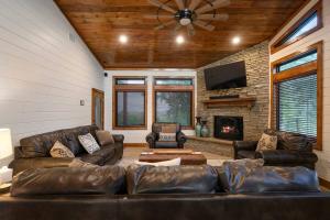 a living room with leather couches and a fireplace at The Heights - Luxury Cabin with Mountain Views & Hot Tub in Stephens Gap