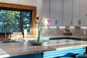 a vase of flowers on a counter in a kitchen at The Heights - Luxury Cabin with Mountain Views & Hot Tub in Stephens Gap +34 photos